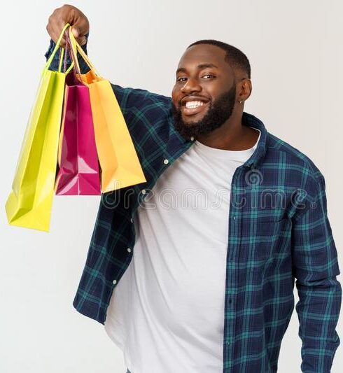 happy african american man holding shopping bags white background holidays concept 150127816 e1673897132331